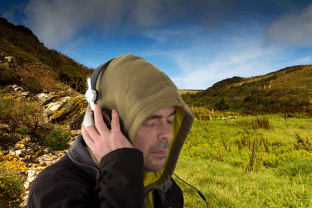 Man in hoodie listening to music on headphones
