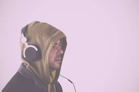 Man in hoodie listening to music on headphones Vintage Retro Filter.の写真素材