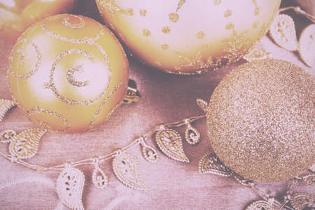 Festive gold Christmas decorations on a fabric background Vintage Retro Filter.