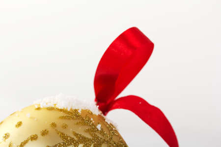 Gold Christmas decorations in white snow for a backgroundの写真素材