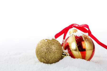 Gold Christmas decorations in white snow for a backgroundの写真素材