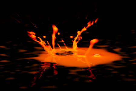 Colorful paint drop splashing on black a backgroundの写真素材