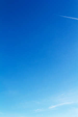 Clear blue sky with light white clouds and trailsの写真素材