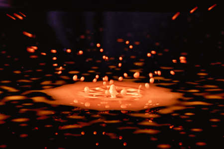 Colorful paint drop splashing on blackの写真素材