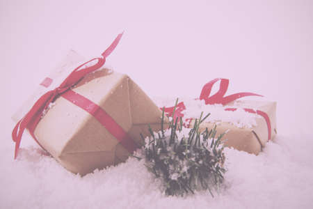 Christmas presents wrapped in brown paper with red ribbon Vintage Retro Filter.の写真素材