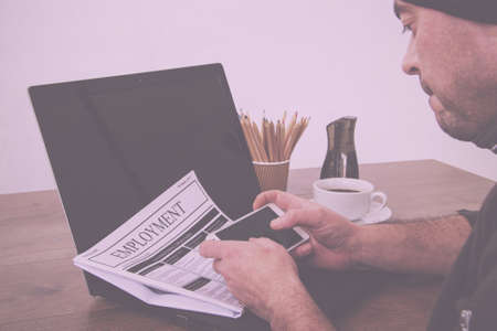 Searching for a new job or employment in a newspaper Vintage Retro Filter.
