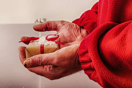 Open hands holding a present wrapped in a red ribbon HDR Filter.の写真素材