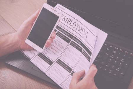 Searching for a new job or employment in a newspaper Vintage Retro Filter.