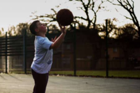 Child practicing playing basketball in a local parkの写真素材