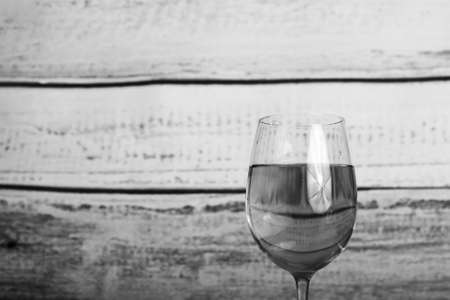 Glass of white wine being poured from a bottleの写真素材