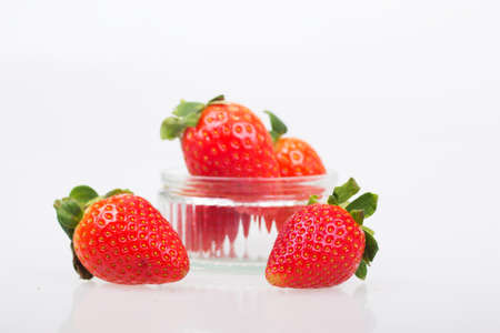 Bright red strawberries against a white coloured background