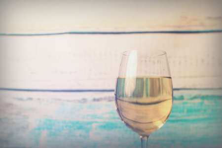 Glass of white wine being poured from a bottleの写真素材