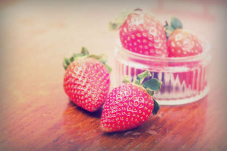 Bright red strawberries against a rustic wooden backgroundの写真素材