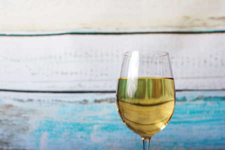 Glass of white wine being poured from a bottleの写真素材