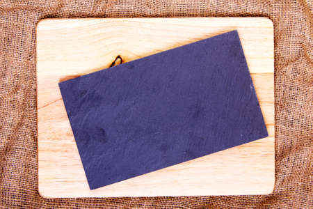 Wooden and slate chopping board on a hessian sackの写真素材