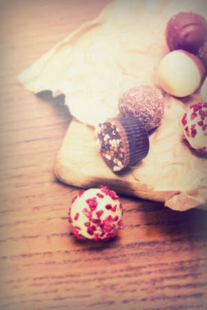 Selection of delicious chocolates on rustic background