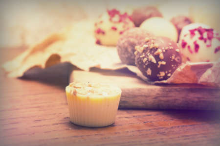 Selection of delicious chocolates on rustic background