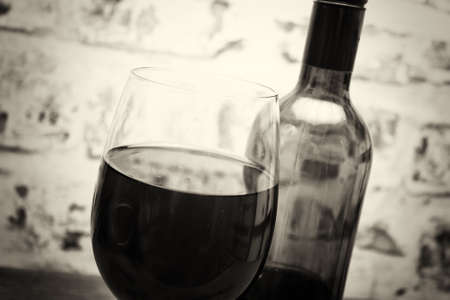 Bottle of red wine with glass ready to be poured