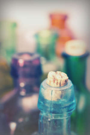 Selection of coloured glass bottles on a rustic backgroundの写真素材