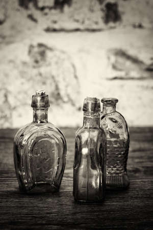 Selection of coloured glass bottles on a rustic backgroundの写真素材