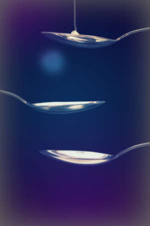 Honey pouring from a spoon against a dark backgroundの写真素材