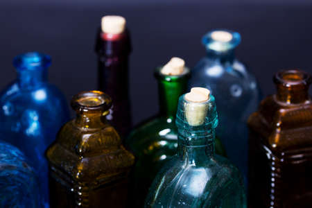 Old colourful vintage bottles against a dark background