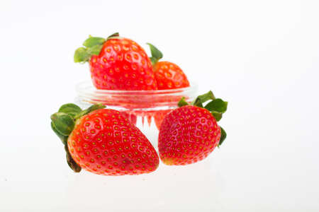 Bright red strawberries against a white coloured backgroundの写真素材
