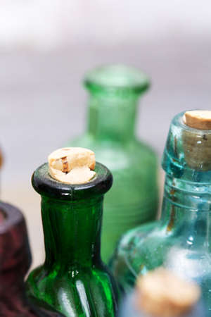Selection of coloured glass bottles on a rustic backgroundの写真素材