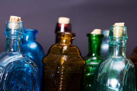 Old colourful vintage bottles against a dark backgroundの写真素材