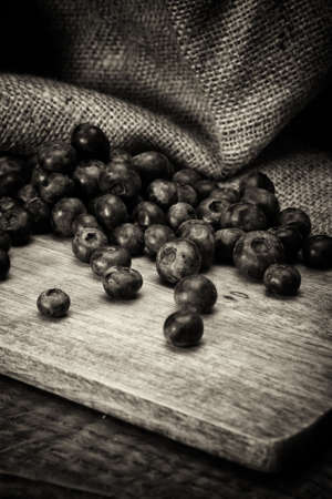 Blueberries spilt over a rustic wooden backgroundの写真素材