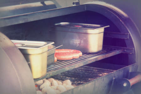 Hot dogs cooking on a bbq at a market