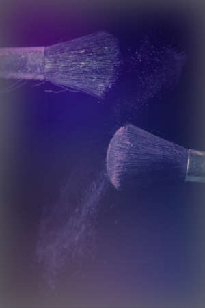 Make up brush with purple dust on a black backgroundの写真素材