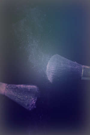 Make up brush with purple dust on a black backgroundの写真素材