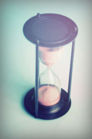 Large black hourglass against a light blue backgroundの写真素材
