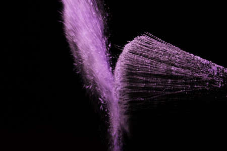 Make up brush with purple dust on a black backgroundの写真素材