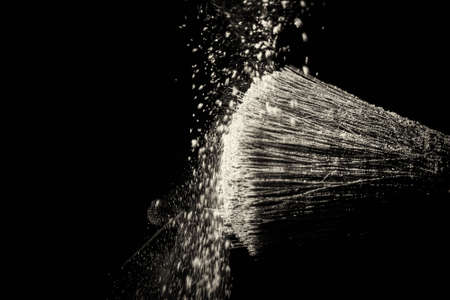 Make up brush with purple dust on a black backgroundの写真素材