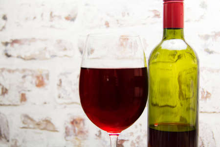 Bottle of red wine with glass ready to be pouredの写真素材
