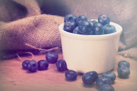 Pot of blueberries on a rustic wooden backgroundの写真素材