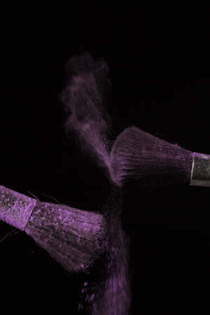 Make up brush with purple dust on a black backgroundの写真素材