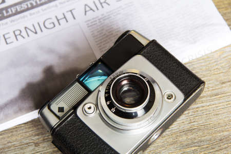 Old vintage retro camera with mocked up daily newspaperの写真素材