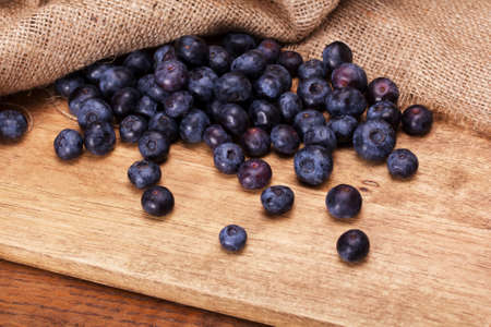 Blueberries spilt over a rustic wooden backgroundの写真素材