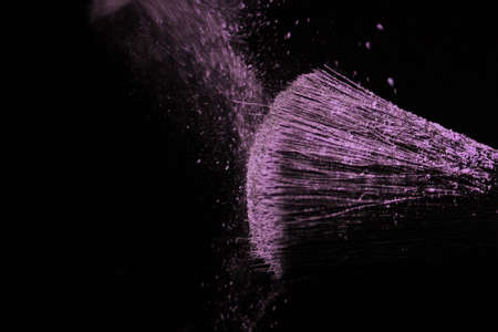 Make up brush with purple dust on a black backgroundの写真素材