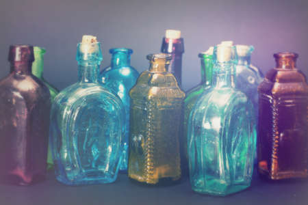 Old colourful vintage bottles against a dark background