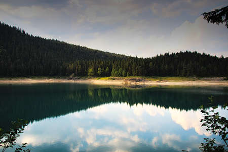 a small idyllic lake with a smooth surfaceの写真素材