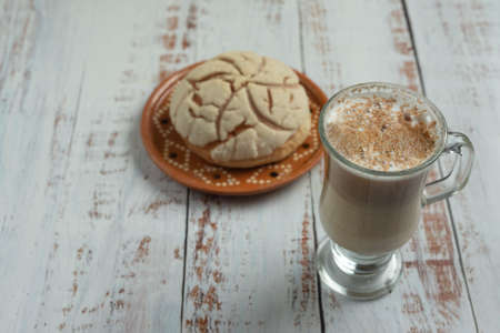 vanilla shell bread with cappuccino coffee on wooden table