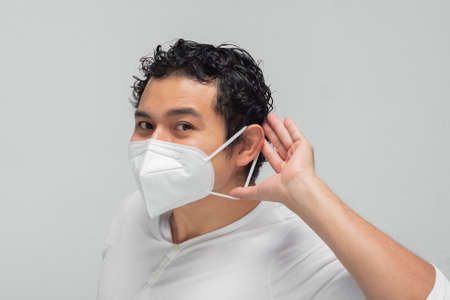 Hispanic young man with curly hair with face mask