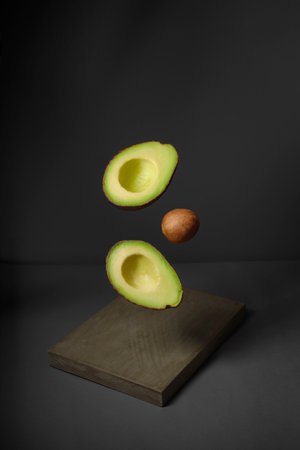 Avocado in the air rustic wooden table. Raw fruits with healthy green food. concept fruit flying...