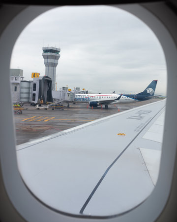 queretaro, queretaro, 20 08 23, Mexican plane parked at the airport with the turret in the background, seen from the wing window of an airplaneのeditorial素材