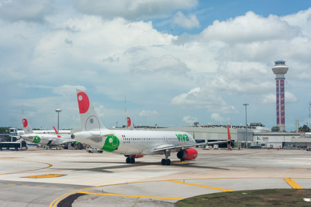 Cancun, Quintana Roo, 20 08 23, Two Mexican airline planes parked at the airport during a cloudy day and people carrying luggageのeditorial素材