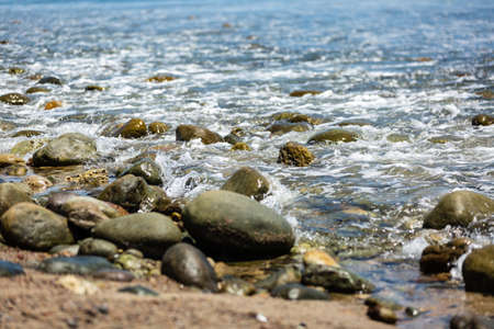 Water rushing over rocks on a beachの写真素材